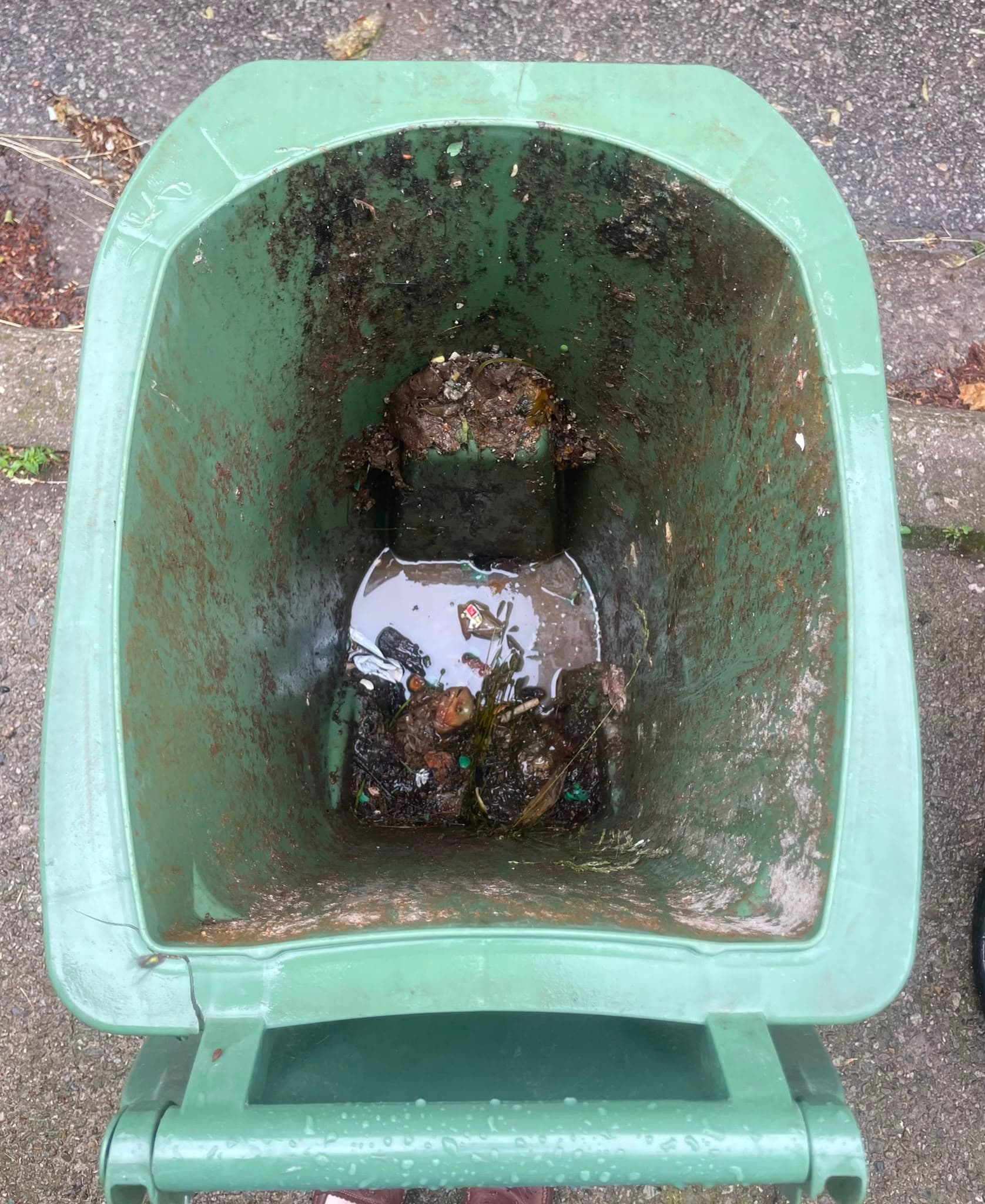Excessively dirty green garbage can interior